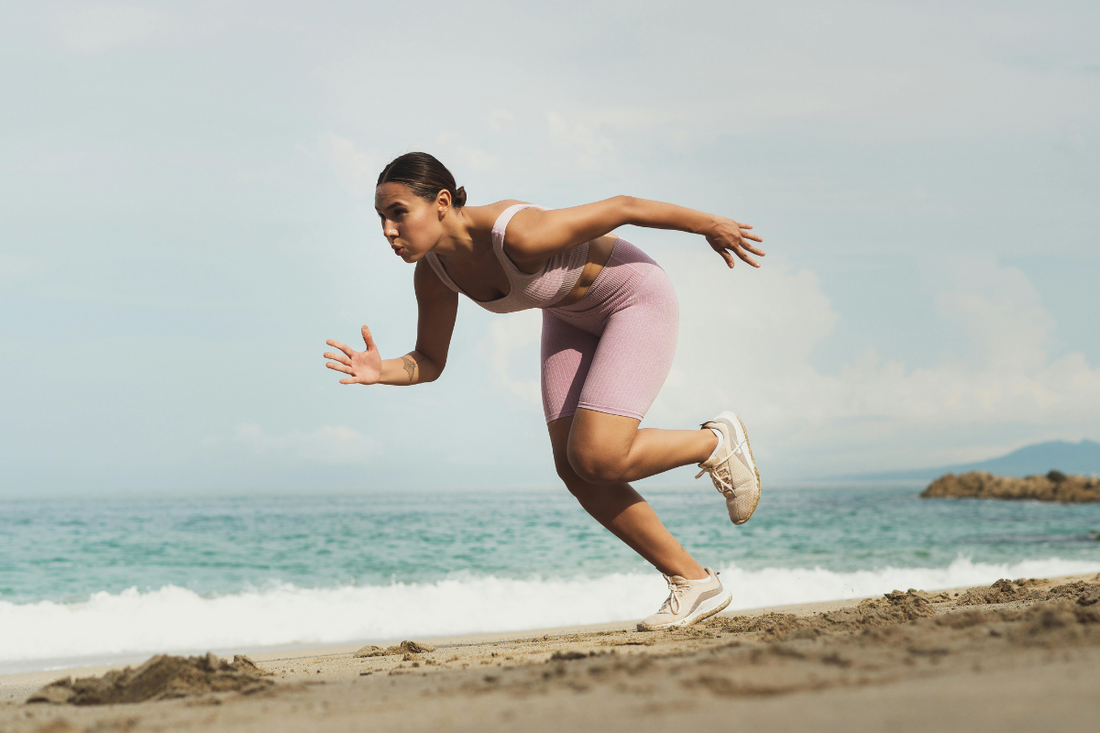 Woman running on the beach after using Crea-tor™ creatine and taurine supplement—energised, strong, and focused on performance and recovery.