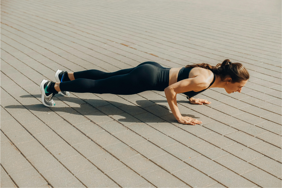 Fit woman in her 40s doing a press-up to build upper body strength while using the best creatine supplement for women’s muscle tone, recovery, and energy.