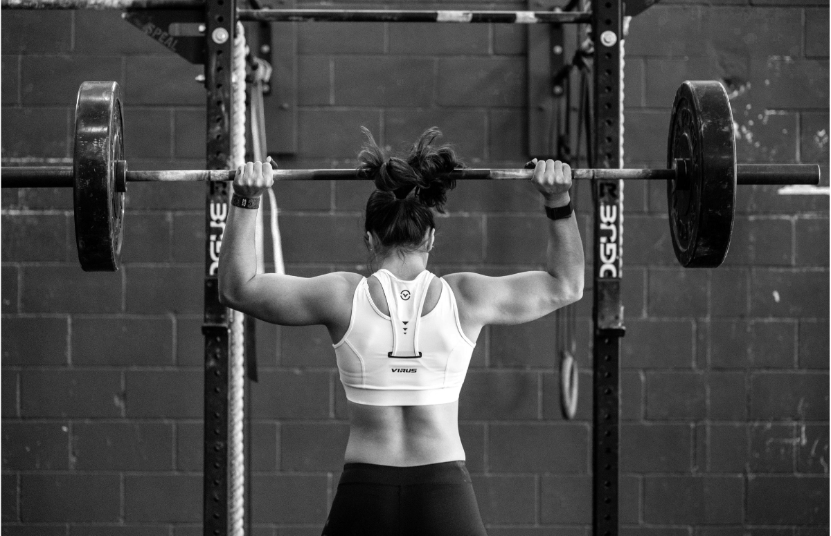 Woman lifting weights overhead, powered by Crea-tor™ creatine and taurine from ME MAINTAIN | EXTEND® to support UK training goals.