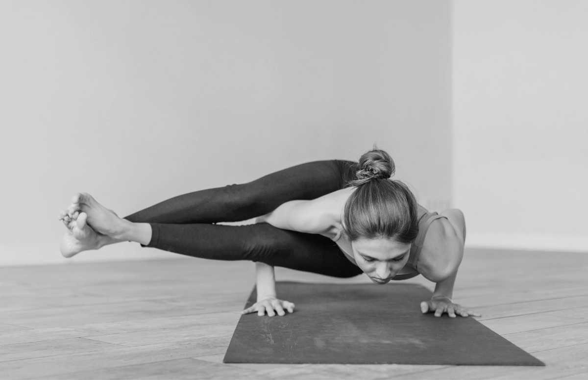 Woman in advanced yoga pose using Crea-tor™ creatine and taurine by ME MAINTAIN | EXTEND® to support flexibility and wellness.