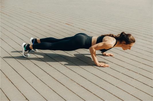 Fit woman in her 40s doing a press-up to build upper body strength while using the best creatine supplement for women’s muscle tone, recovery, and energy.